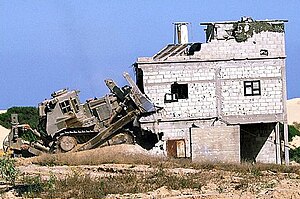 An IDF Caterpillar D9 armored bulldozer razing a house during the Second Intifada (2000-2005) IDF-D9-demolishes-Palestinian-structure-01.jpg