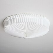 Foto van een plafondlamp van gevouwen papier. De foto van de lamp is genomen tegen een witte achtergrond.