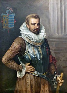 Painting of a bearded man in early 16th-century attire including prominent ruff collar, wearing a decorative breastplate, with his right hand resting on his hip and his left hand grasping a cane or riding crop.
