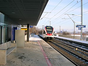 Red-and-white train arrives at side platform