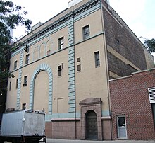 A pale colored building with small windows