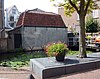 Berging van Markt 25 aan de Zeugstraat. Het woonhuis Markt 25, is Rijksmonument 16854. De berging, een gemeentelijk monument, heeft een blinde gepleisterde gevel, staat aan het water, aan de onderkant zijn 4 Y-vormige ankers, houten goot met balkankers en rode dakpannen. (Gouda-Centrum)