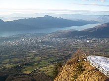 Vue plongeante sur une vallée occupée par un lac et une agglomération