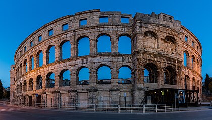 Vista do exterior da Arena de Pula, Croácia. O anfiteatro romano foi construído entre 27 a.C. e 60 d.C. e é uma das maiores arenas do antigo Império Romano que ainda está conservada. Ao mesmo tempo, trata-se do monumento antigo melhor preservado na Croácia e o único anfiteatro do mundo que ainda conserva suas quatro torres laterais com as três ordens arquitetônicas romanas totalmente preservadas (definição 7 398 × 4 184)