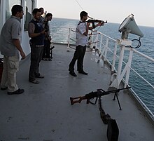 Private guard escort on a merchant ship providing security services against pirates. Armed guard escort on a merchant ship.jpg