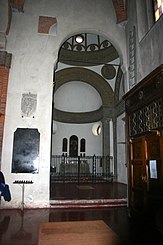 Photograph. A church interior. A horseshoe-shaped chapel. White walls.