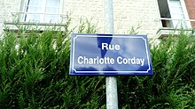 Plaque de rue avec écrit en blanc sur fond bleu "Rue Charlotte Corday".
