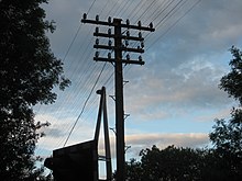 Telegraph pole with spars, insulators and open wires on a now decommissioned Railway Pole Route, Eccles Road, Norfolk, United Kingdom Pole Route.jpg