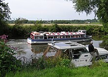 Leisure activities on the River Avon at Avon Valley Country Park, Keynsham, United Kingdom. A boat giving trips to the public passes a moored private boat. River avon at keynsham arp.jpg