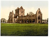 Photographie couleur du dix-neuvième siècle montrant une église partiellement ruinée.