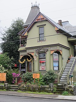 Photograph of a Victorian house with signs in the front garden as well as displayed in windows