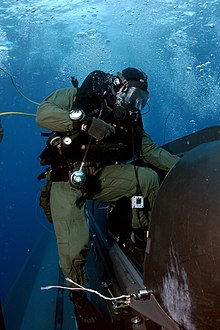 A SEAL Delivery Team member climbs aboard a delivery vehicle before launching from the back of the submarine USS Philadelphia. US Navy 050505-N-3093M-001 A member of SEAL Delivery Vehicle Team Two (SDVT-2) climbs aboard one of the team's SEAL Delivery Vehicles (SDV) before launching from the back of the Los Angeles-class attack submarine USS Philadelph.jpg