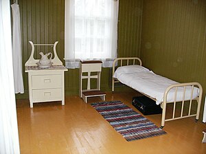 A prie-dieu, which is used for private Christian prayer, situated in the room of a historic house. Val Jalbert historic housing interiors 7.JPG