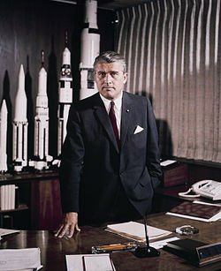 1964 májusában a Marshall Space Flight Center-beli íróasztalánál (Huntsville, Alabama) a kifejlesztett és a készülő modellek makettjével