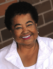 a smiling woman with short dark curly hair