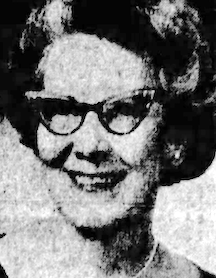 A smiling older white woman, with bouffant coiffed hair and cat-eye glasses