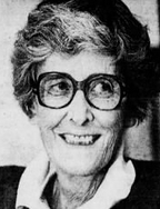 An older white woman with short grey hair, smiling and wearing glasses.