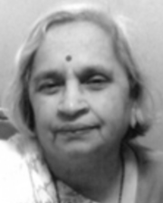 An older South Asian woman with grey hair cropped to chin length; she is wearing a sari.