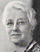 An older white woman with white hair, wearing glasses