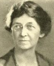 A middle-aged white woman wearing glasses