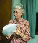 an older white woman holding a document