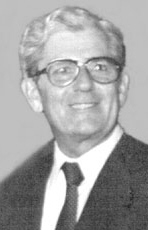 Black and white photo of elderly Paul Dumont, wearing a suit and tie, with eyeglasses