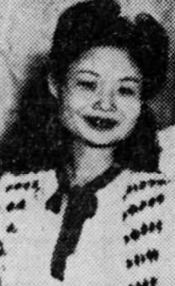 A young Chinese woman, smiling, wearing a light-colored dress.
