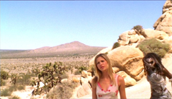 Две женщины, стоящие в пустынном пейзаже.
