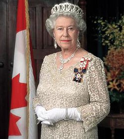 Queen Elizabeth II. The Queen poses for different official portraits in each country. Here she poses as the Queen of Canada wearing the insignia of the Order of Canada and standing beside the Canadian flag.