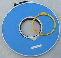 IBM tape reel with white write ring in place, and an extra yellow ring. Write protect ring.agr.jpg