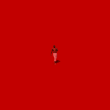 Diddy shirtless and wearing white pants mid-stride in the middle of a red box