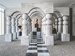 Three halls of portals made of black and white marble displays an sculpture each at their ends