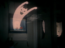 A cartoon like image of a grinning cat leaps out of a picture of Blanche in the aunt's house