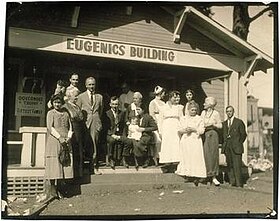 Winning family of a Fitter Family contest stand outside of the Eugenics Building (where contestants register) at the Kansas Free Fair, in Topeka, Kansas. Eugenics-Fitter-Families-Contest-Winners-Topeka-Kansas.jpg