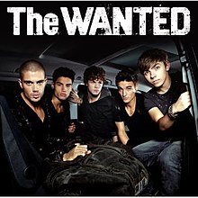 All the band's members sitting in an RV. From left to right, we see Max George, Siva Kaneswaran, Jay McGuinness, Tom Parker, and Nathan Sykes. We see the band's name above in white.