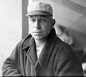 Black and white image of Hugh Duffy in a baseball cap and jacket, facing left