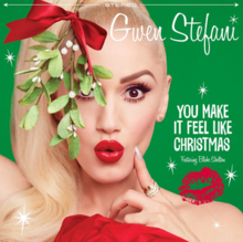 A green background displaying the upper hand of Stefani holding a piece of mistletoe above her head.