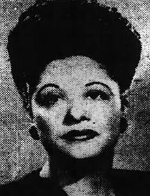 An African-American woman with a high updo hairstyle and stylish 1940s makeup.
