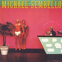 The cover consists of two tanned models looking up and a man wearing a fedora, black suit and white tie, and white gloves, reading a comic book. The artist's name is on top in yellow text and the album title is in cursive neon text.