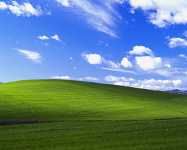 The Bliss wallpaper. Rolling green hills and a blue sky with stratocumulus and cirrus clouds.