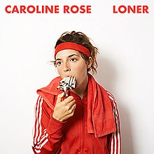 Caroline Rose wearing a red tracksuit, sweatband and towel, with two dozen cigarettes in her mouth