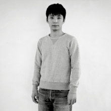 The single's standard edition cover. It is edited to grayscale and features Gen Hoshino looking at the camera, wearing a casual sweater and jeans.