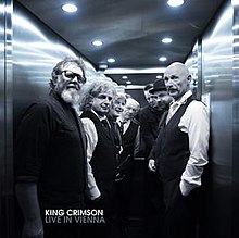 A blue-tinted photograph of King Crimson backstage