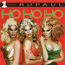 An image of three RuPauls wearing three different colored dress (green, red, and gold). They are standing against a red background with the album's title above them.