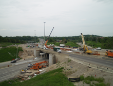 Construction equipment lines a highway overpass