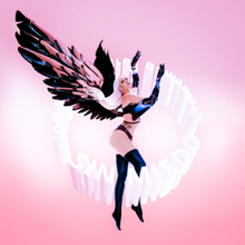 A blonde woman with pink, purple wings and cyber-like gloves against a pink background. She is surrounded by the words "Sin Miedo (del Amor y Otros Demonios)", which are placed in a circular shape.