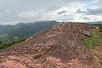 Большой камень с врезанными в него символами и фундаменты зданий.