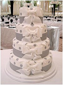 A contemporary white wedding cake decorated with sugar bows.