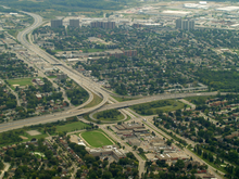 An aerial photo of a 3-legged highway interchange in an urban area