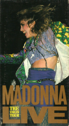 Мадонна танцует, глядя вправо. Она одета в яркий пиджак и пурпурную юбку, с шеи свисает распятие.